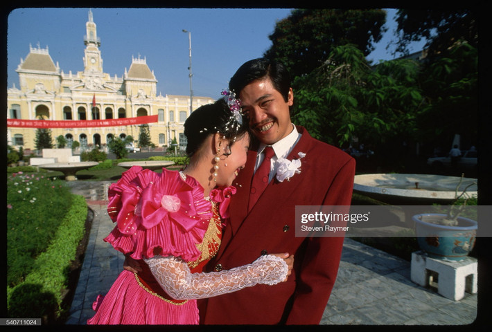 Cặp vợ chồng mới cưới chụp hình kỷ niệm trước trụ sở UBND TP. HCM, năm 1994. Ảnh: Steven Raymer/ Getty Images.