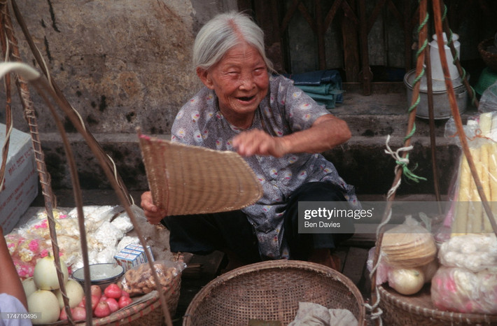 Cụ bà bán hoa quả và các loại quà vặt trên vỉa hè Hà Nội.