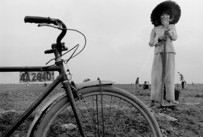 Em bé cầm cuốc giúp gia đình làm ruộng. Ảnh: Larry Towell - Magnumphotos.com