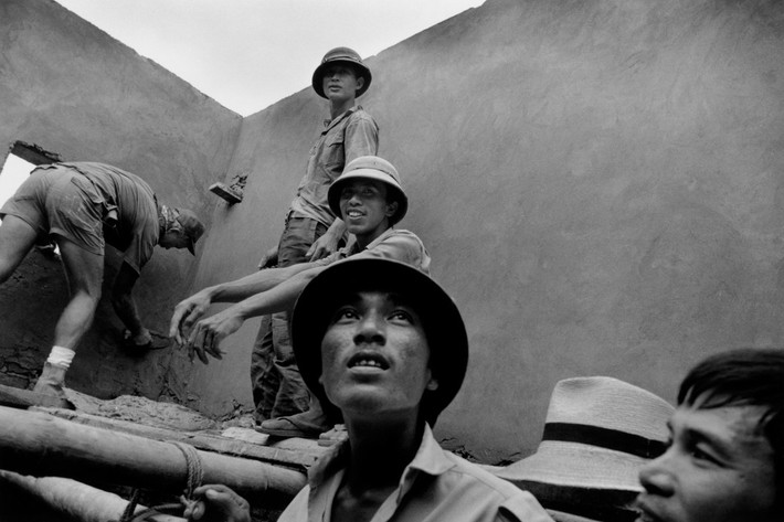 Cựu binh Mỹ Chuck Nixon tham gia xây dựng một bệnh xá từng bị bom Mỹ phá hủy thời chiến tranh Việt Nam cùng các công nhân người Việt tại Yên Viên. Ảnh: Larry Towell - Magnumphotos.com