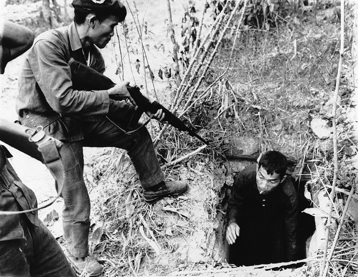 Lính Sài Gòn bắt giữ một người trong một căn hầm trong rừng, tháng 1/1964. Ảnh: Horst Faas/ AP.