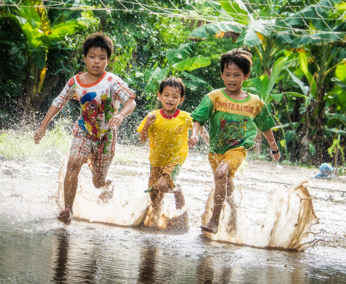 Trẻ em chơi đùa trên đường làng ngập nước ở Tây Ninh. Ảnh: Raymond Low - 500px.com