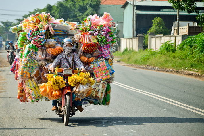 Người phụ nữ trổ tài chở hàng bằng xe máy. Ảnh: Raymond Low - 500px.com