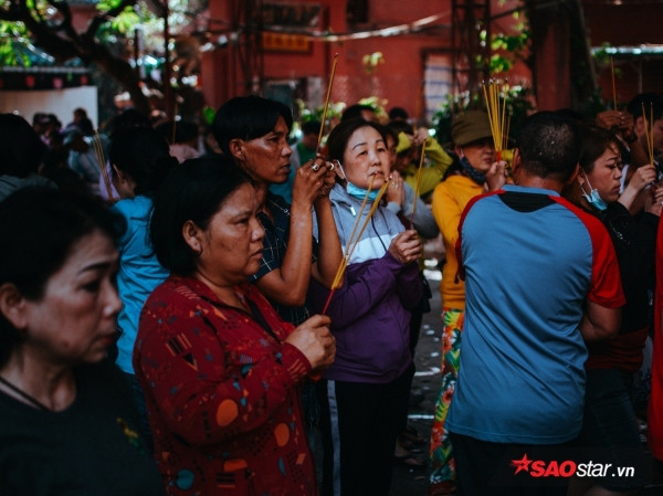 Chờ đợi khá lâu không chen chân được vào trong chùa, nhiều người đốt hương khấn vái ngay tại ngoài điện.