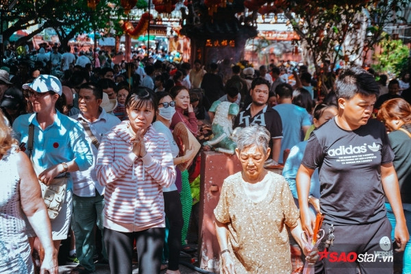 Theo quan niệm dân gian: “Mùng 8 cúng sao, mùng 9 cúng chư thiên (vía Ngọc Hoàng), mùng 10 cúng đất”. Vì vậy, mỗi năm, cứ đến độ mùng 9 âm lịch, người người ở khắp nơi lại kéo nhau về chùa Phước Hải, hay còn gọi là chùa Ngọc Hoàng (Mai Thị Lựu, Q.1, TP. HCM) để thắp hương, khấn vái và cầu may cho một năm mới ấm no, hạnh phúc. Ảnh: Dù giữa trưa nhiệt độ trên 34 độ C, nhiều người vẫn đổ về chùa Ngọc Hoàng để cầu may.