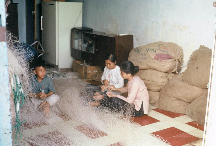 Các thiếu nữ sửa lưới đánh cá. Ảnh: Tom Twitty.