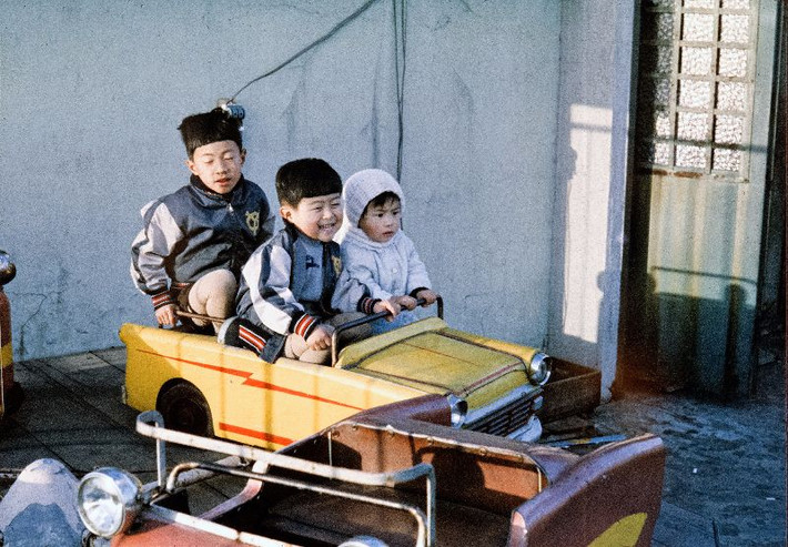 Ba anh em trên chiếc xe ô tô đồ chơi. Ảnh: Vintage Japan-esque.