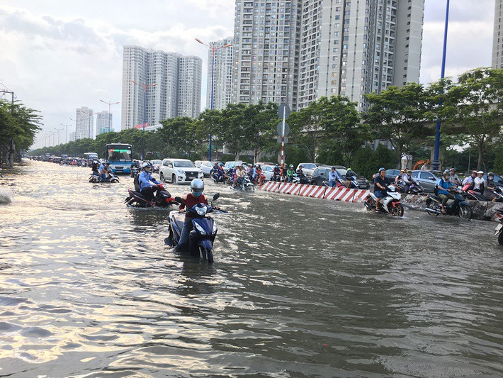 Triều cường tại TP.HCM hiện đã vượt báo động 3 (1,5m), nhiều tuyến đường gần sông rạch ngập nặng, người dân di chuyển khó khăn. Ảnh: PLO