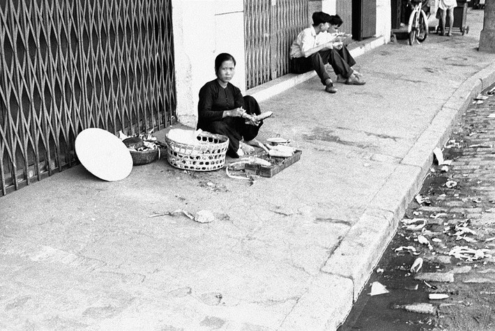 Người phụ nữ bán bắp nướng trên hè phố. Ảnh: Getty.