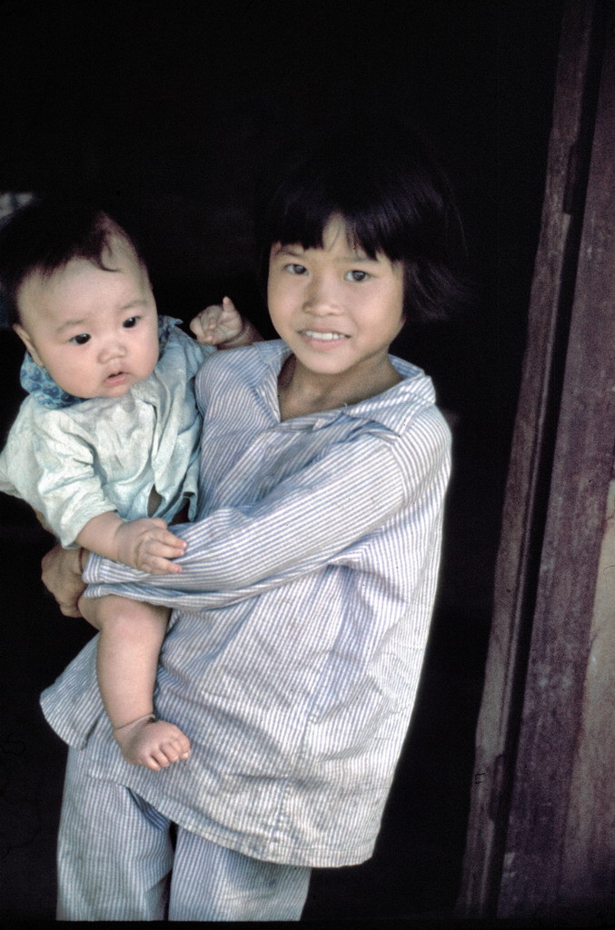Bé gái bế em nhỏ. Ảnh: Edward Palm.