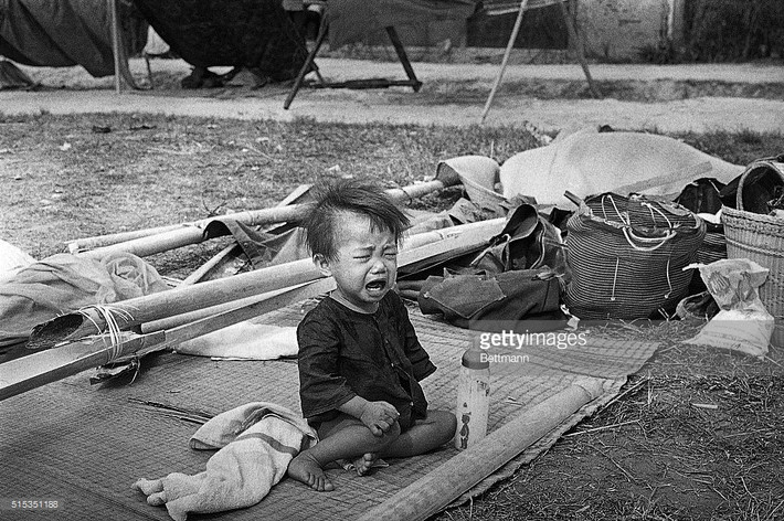 Em bé khóc nhè đòi bố mẹ trong đoàn người di tản chiến tranh ở Long Khánh, Đồng Nai, đầu tháng 4/1945. Ảnh: Getty Images.