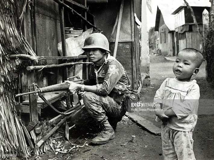 Em bé vô tư đứng giữa khu vực chiến sự tại một ngôi làng ở miền Nam Việt Nam năm 1968. Ảnh: Getty Images.