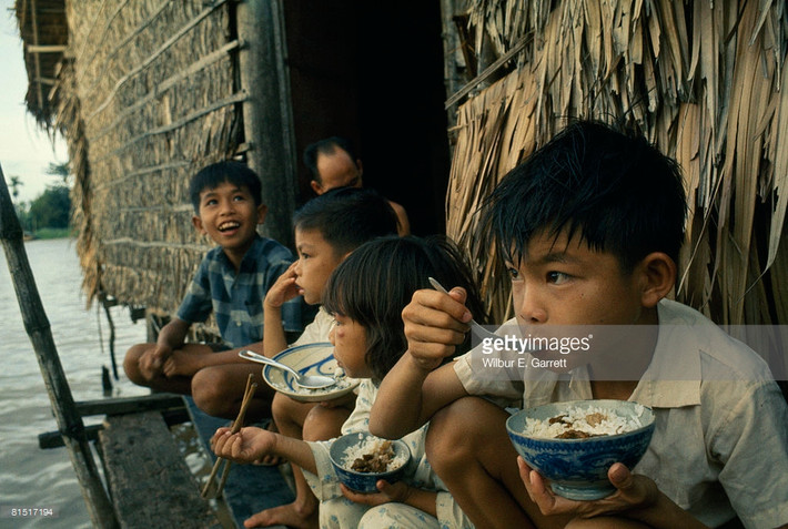 Bữa cơm ở hiên nhà trên sông nước của trẻ em Cần Thơ năm 1967. Ảnh: Getty Images.
