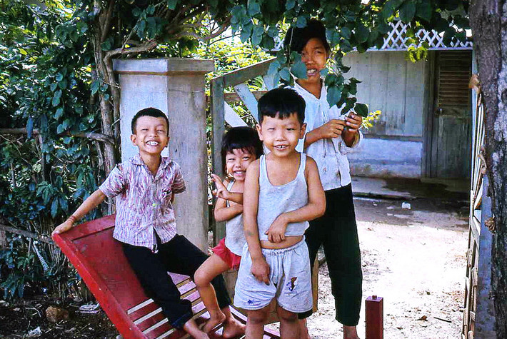Những đứa trẻ cười hồn nhiên trước hiên nhà. Ảnh: Bruce Tremellen.
