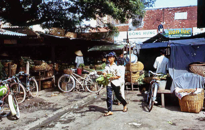 Cậu bé và bó rau ở chợ Vũng Tàu. Ảnh: Bruce Tremellen.