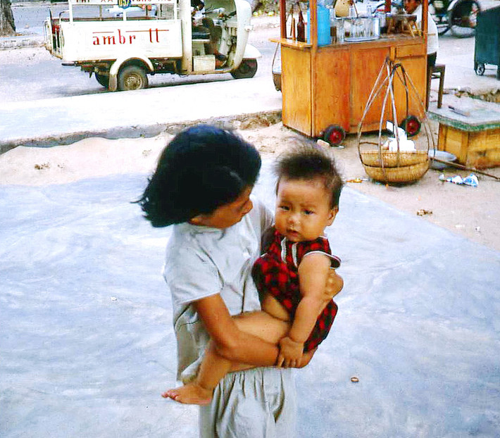 Bé gái bế em nhỏ trên vỉa hè Vũng Tàu năm 1967. Ảnh: Bruce Tremellen.