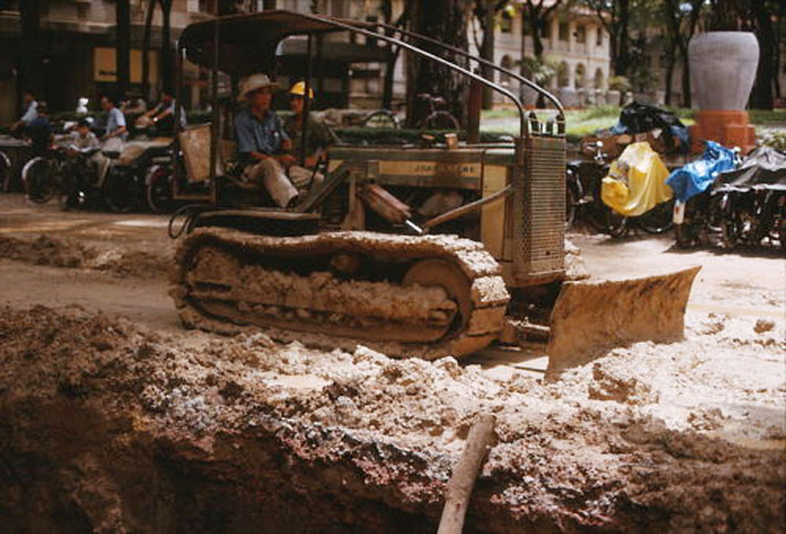 Xe ủi san lấp nền đường sau khi việc lắp đặt đường ống nước hoàn tất. Ảnh: Saigoneer.