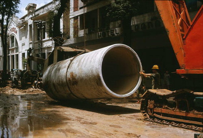 Cần cẩu nâng ống vào vị trí thi công. Ảnh: Saigoneer.