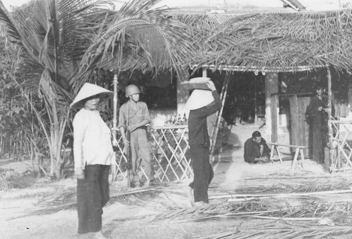 Bên ngoài một ngôi nhà đang được lợp lá dừa ở Quy Nhơn.