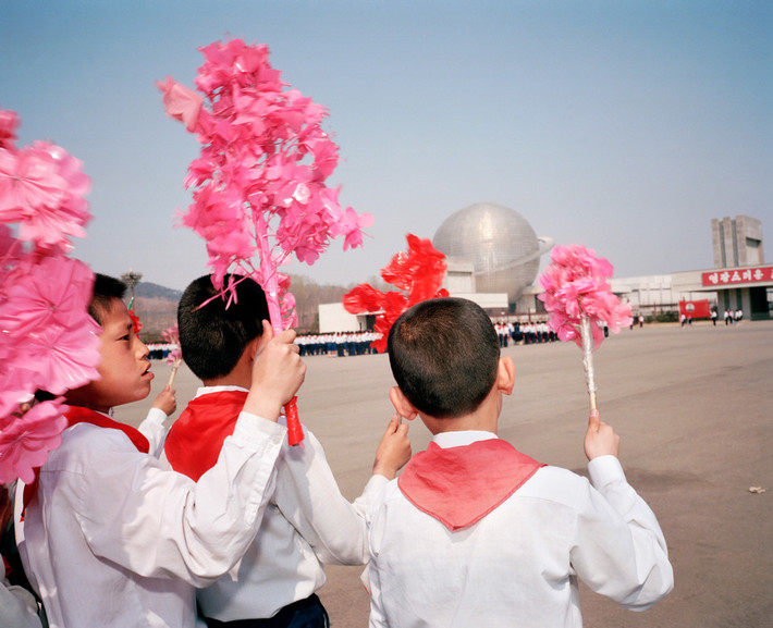 Học sinh vẫy hoa chào mừng các đoàn khách bên ngoài Bảo tàng Công nghệ. Ảnh: Martin Parr/ Magnum Photos.