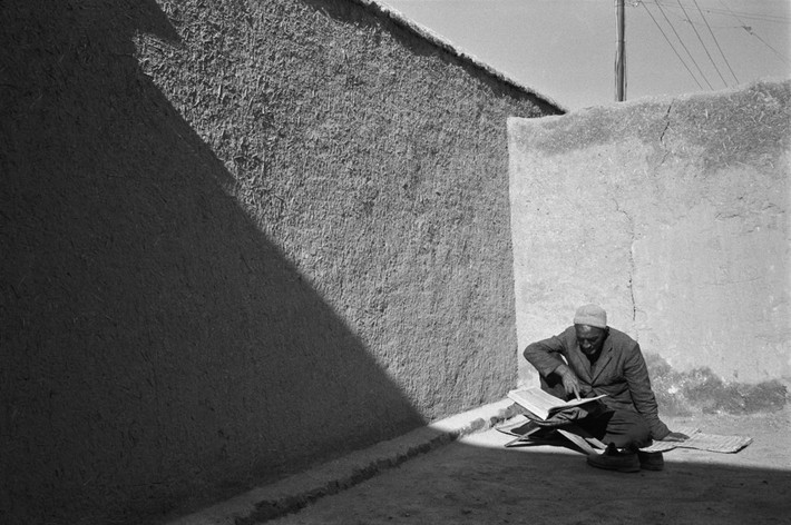 Cụ ông đọc kinh Koran ở góc sân đầy nắng. Ảnh: A. Abbas/ Magnum Photos.