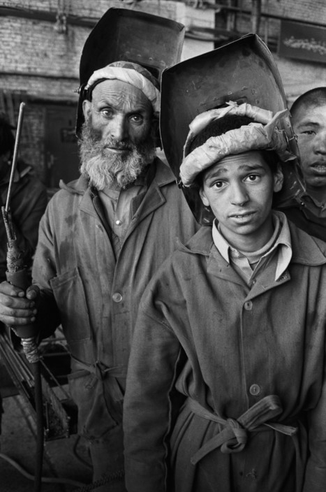 Người công nhân trẻ bên đồng nghiệp cao tuổi ở nhà máy cơ khí Jangalak. Ảnh: A. Abbas/ Magnum Photos.