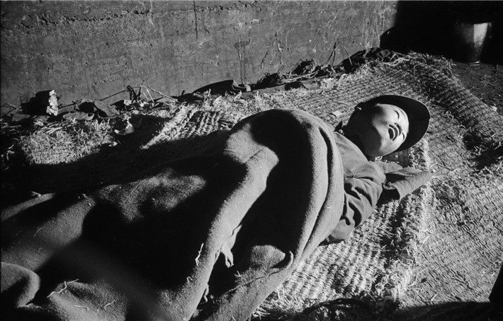 Một cậu bé bị bệnh nằm ở trại tạm cư của thành phố Busan, 1952. Ảnh: Werner Bischof.