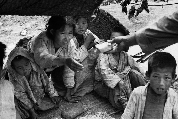 Người phụ nữ tạm cư ở làng San Jang Ri nhận một phần thực phẩm từ binh sĩ đồn trú trong làng. Ảnh: Werner Bischof.