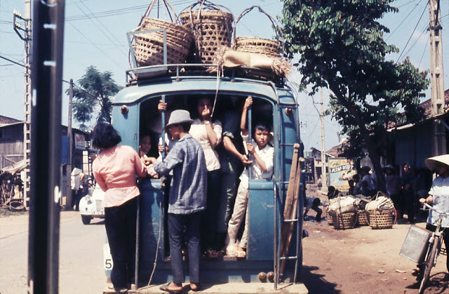 Hành khách "bám càng" phía sau một chiếc xe khách quá tải. Ảnh tư liệu.