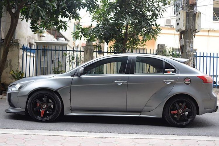 Điểm đặc biệt của chiếc Mitsubishi Lancer Ralliart này đó là bộ widebody "hàng thửa" được thực hiện bởi xưởng độ QS Performance tại Hà Nội. Mang phong cách các mẫu widebody tới từ hãng Rocket Bunny hay Liberty Walk, các vòm bánh của xe đã được nới rộng bằng những nẹp composite bắn đinh tán, đem tới cho Lancer vẻ ngoài thể thao hơn.