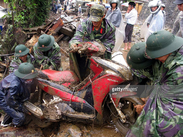 Lực lượng quân đội kéo một chiếc xe máy bị chôn vùi trong bùn đất sau trận lũ quét ở Sa Pa, Lào Cai ngày 5/9/2013. Trận lũ quét này đã khiến 8 người thiệt mạng, 10 người mất tích.