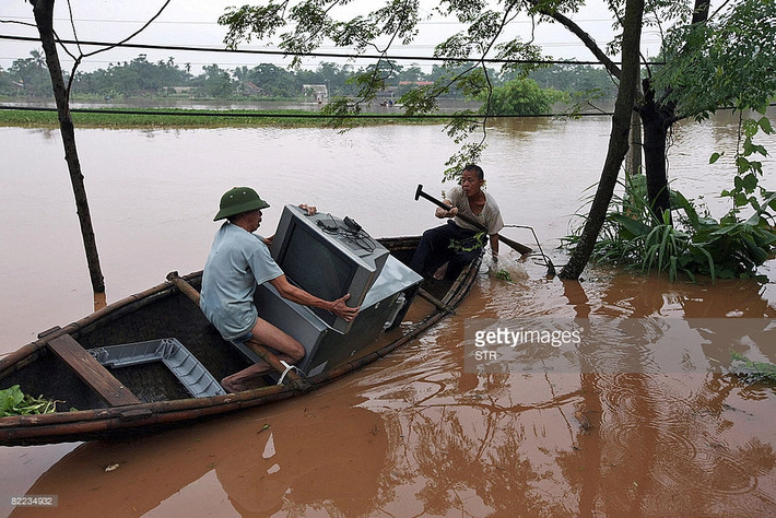 Người dân Hạ Hòa, Phú Thọ vận chuyển các tài sản có giá trị bằng thuyền trong trận lụt gây ra bởi bão Kammuri (bão số 4), ngày 9/8/2008. Tình trạng lũ lụt và lở đất do cơ bão gây ra đã khiến 86 người chết và 39 người mất tích trên toàn vùng núi phía Bắc Việt Nam.