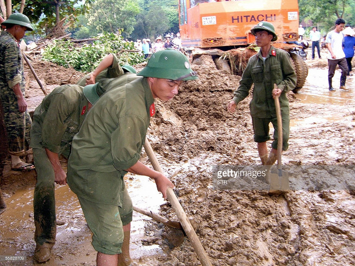 Lực lượng quân đội làm sạch bùn đất trên đường sau trận lũ quét gây ra bởi cơn bão Damrey (bão số 7) ở Cát Thịnh, Yên Bái ngày 30/9/2005. Trong đợt thiên tai này, riêng tỉnh Yên Bái có 50 người thiệt mạng. Hình ảnh nằm trong loạt ảnh thiên tai ở Việt Nam được thực hiện bởi phóng viên của các hãng truyền thông quốc tế.