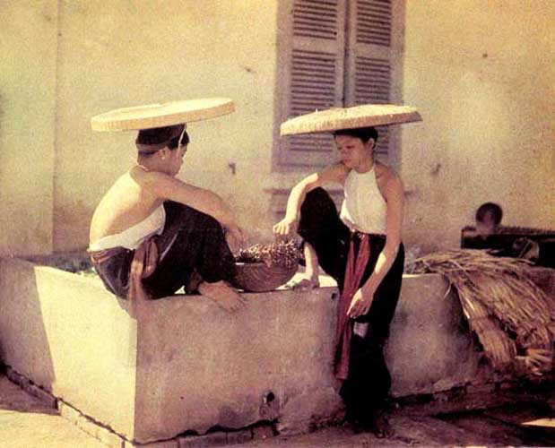 Hai cô gái Việt Nam mặc áo yếm, đội nón quai thao. Ảnh: Léon Busy.