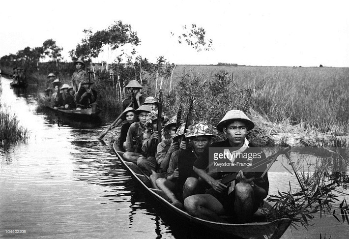 Các chiến sĩ du kích di chuyển bằng thuyền trên chiến trường Tây Nam Bộ năm 1966. Ảnh: Getty.