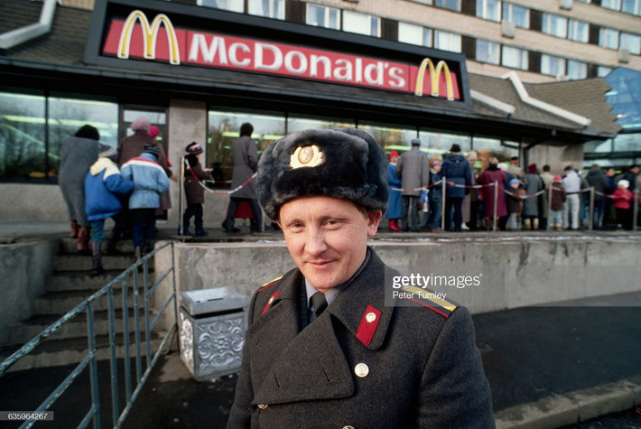 Một cảnh sát đứng bên hàng người chờ vào cửa hàng McDonald's mới mở trên phố Gorky ở Moscow, Nga năm 1990, một năm trước khi Liên Xô sụp đổ. Ảnh: Peter Turnley/ Getty Images.