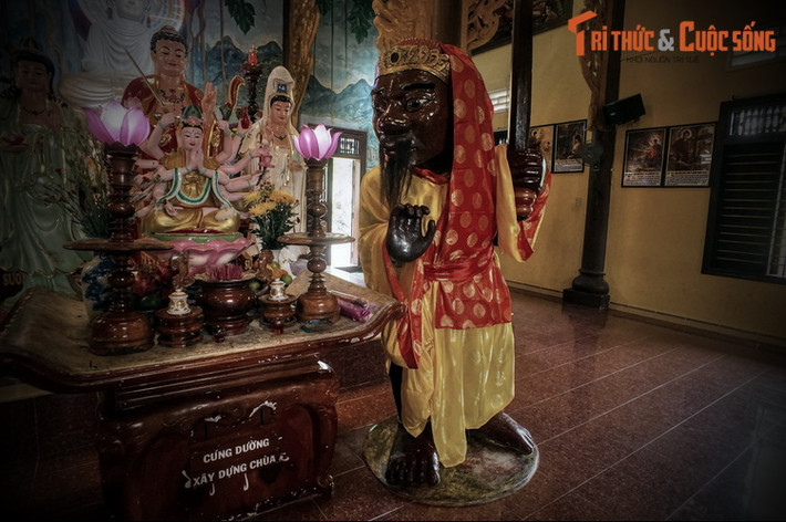 Tượng Ông Đỏ cao 2 mét 42, tay trái cầm binh khí, tay phải đưa cong ngang trước ngực, bắp tay đeo chuỗi hạt có hình cánh sen ở giữa, cổ chân trái đeo hình rắn Naga, cổ chân phải đeo vòng kiềng có hình cánh sen ở giữa.