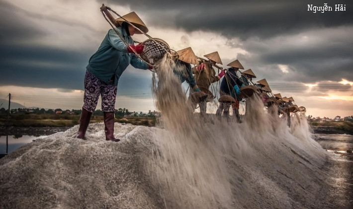 Muối là gia vị quen thuộc, không thể thiếu trong bữa ăn hàng ngày. Nhưng không phải ai cũng biết được để làm ra từng hạt muối, diêm dân vất vả chừng nào. Trong ảnh là cảnh lao động vất vả của diêm dân hòn Khói (Khánh Hòa). Ảnh: Hai Nguyen.