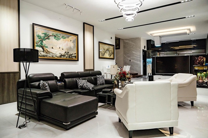 Mỗi căn phòng trong biệt thự được Quốc Trường thiết kế theo một phong cách khác nhau. Riêng phòng khách chiếm diện tích khá rộng. Không gian chung này có phong cách hiện đại, nổi bật với bộ sofa trắng đen sang trọng và nhiều tranh ảnh trang trí. Ảnh: Vietnamnet