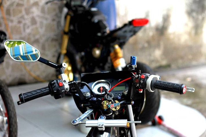 Ở phía trên ghi-đông, chiếc Satria F150 độ khủng cũng được gắn thêm nhiều món phụ tùng là niềm "khao khát" của dân chơi như cùm phanh/côn Brembo, trợ lực Ohlins, gương hậu Rizoma, bình dầu Bonamici...