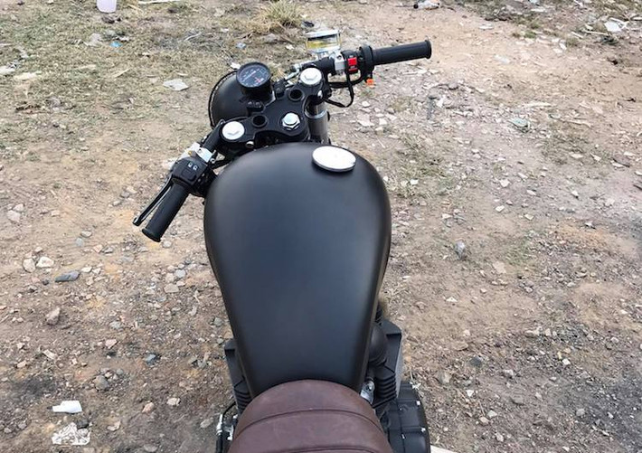 Thay vì gù ghi-đông cùng tay lái cao nguyên bản của Bonneville, chiếc xe đã được thay cặp tay lái clip-on thể thao hơn theo đúng phong cách cafe racer. Ở phía trên chảng ba, cụm đồng hồ nguyên bản của xe cũng được "rút gọn" lại chỉ bằng một đồng hồ điện tử đa năng duy nhất.