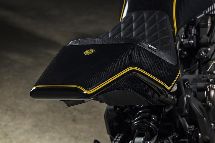 Bình xăng có thiết kế nối liền với phần đuôi xe cũng được làm bằng sợi carbon và hoàn thiện tương tự. Để lắp được phần đuôi mới, đương nhiên xưởng độ xứ Đài đã phải chế lại khung phụ của xe. Nằm trên phần đuôi là chiếc yên solo cổ điển với bề mặt bọc da chần chỉ vân con thoi.