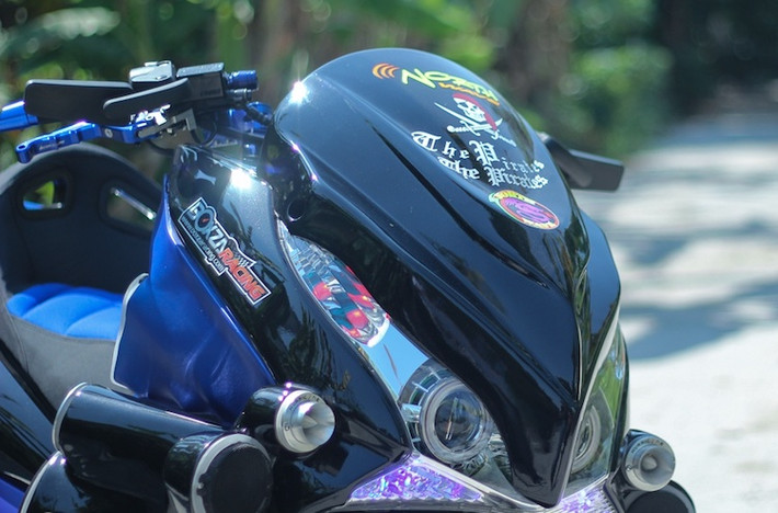 Dựa trên chiếc PCX thế hệ đầu tiên, bộ đèn pha của xe đã được độ lại với cặp đèn dạng thấu kính projector như "mắt cú". Phần trước của xe còn được ốp mặt nạ khiến đèn pha đơn của PCX trông như một cặp pha kép giống "đàn anh" Honda Forza 250. Bộ mâm 5 cánh kép xoắn trên bản độ này được giữ nguyên, nhưng có hệ thống phanh trước độ lại với đĩa kiểng.