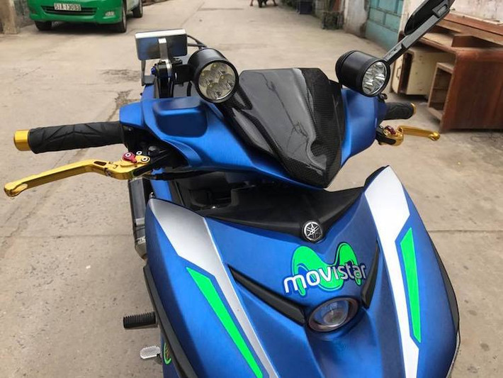 Trên bản độ này, phần đầu nguyên bản của Exciter kèm đèn pha trươc sddax được thay bằng đầu từ Nouvo thế hệ thứ 5, với điểm nhấn là phần mặt nạ dán sợi carbon thật. Do không còn đèn pha nên khe gió mặt nạ trước của xe đã được chế mủ để lắp một đèn LED bi cầu, bên cạnh cặp LED L4 trên tay lái.