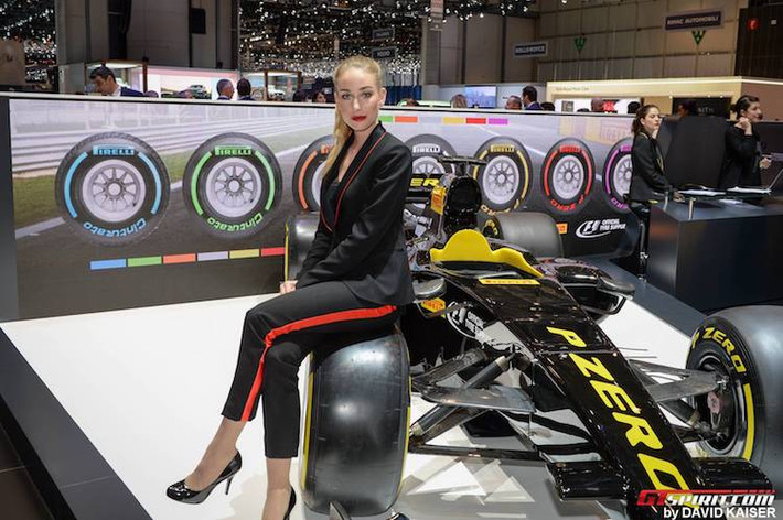 "Chân dài" tại hãng lốp Pirelli trong bộ vest lịch thiệp với tông đen-vàng như chiếc xe đua F1 ở phía sau.