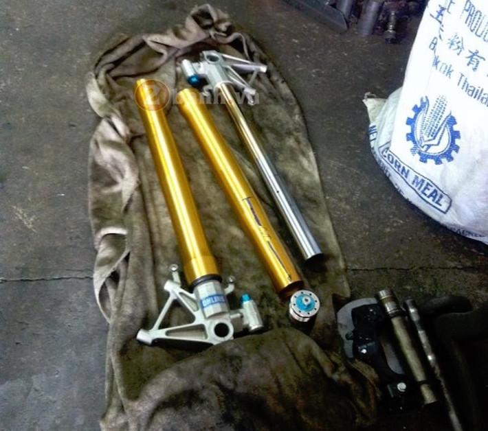 Để có thể lắp được vào Exciter, cặp phuộc Ohlins của RSV4 đã buộc phải được cắt ngắn từ lò xo tới vỏ phuộc, sau đó tiếp tục lắp vào chảng 3 đặc chế để phù hợp với cổ của xe. Đây là công đoạn phức tạp nhất, đòi hỏi độ chính xác cực cao khi cắt phuộc.