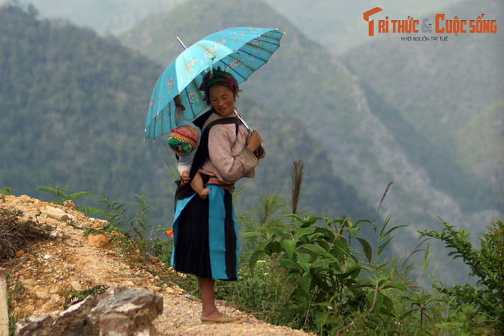 Người mẹ địu con giữa khung cảnh hùng vĩ của cao nguyên đá Đồng Văn, Hà Giang.