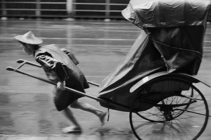 Người kéo xe hành nghề trong cơn mưa. Ảnh: Werner Bischof / Magnum Photos.
