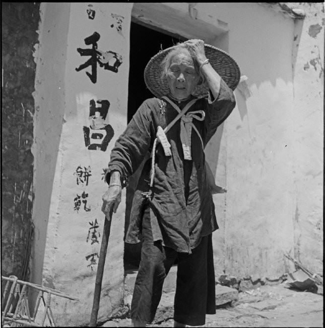 Cụ bà mù lòa địu cháu trên lưng đi hành nghề ăn xin. Ảnh: Werner Bischof/ Magnum Photos.