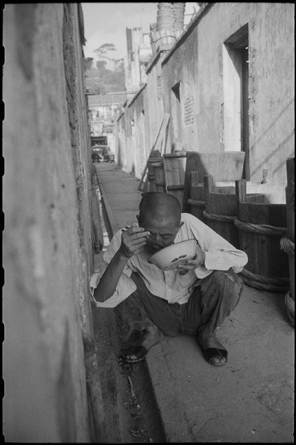 Bữa trưa vội vã trong ngõ hẻm của một người đàn ông. Ảnh: Werner Bischof / Magnum Photos.
